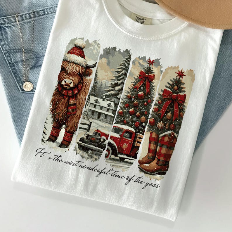 May include: White t-shirt with a festive design featuring a Highland cow in a Santa hat, a snowy landscape, a red truck, a Christmas tree, and cowboy boots. The text "It's the most wonderful time of the year" is printed at the bottom.