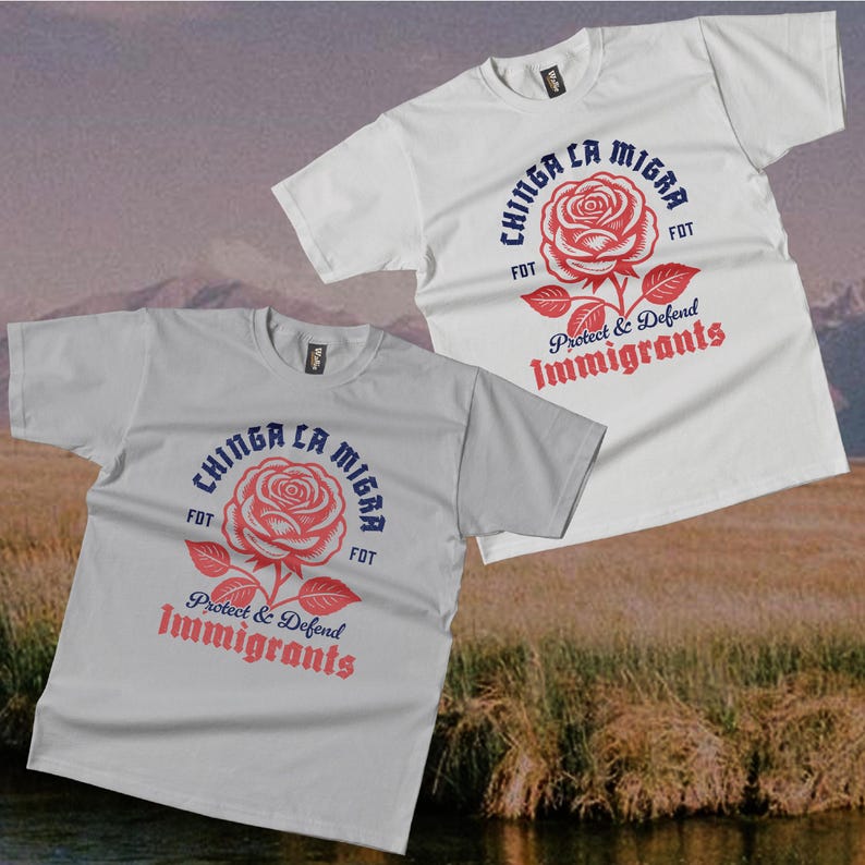 May include: Two t-shirts, one white and one gray, with a floral graphic and text. The design features a red rose with the words "Chinga La Migra" and "Protect & Defend Immigrants" in a stylized font. The shirts are short-sleeved.