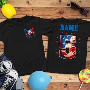 Pu&ograve; includere: Due magliette nere con disegni a tema baseball. Una maglietta presenta una grafica di baseball e mazza con accenti rossi, bianchi e blu. L'altra maglietta ha il numero "5" e la scritta "NAME" in blu.