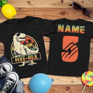 May include: Black t-shirt with a dinosaur graphic wearing sunglasses and the text "FIVE-REX". The back of the shirt has the word "NAME" and the number "5" with claw marks. Accessories include sunglasses, a pineapple, and a blue balloon.