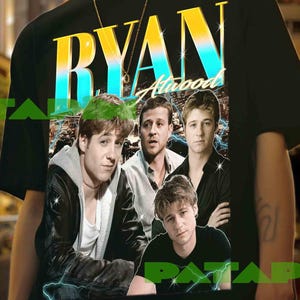 Puede incluir: Camiseta negra con un gráfico de la palabra "RYAN" en amarillo y azul, y una foto de cuatro hombres. La camiseta la lleva una persona con un collar de cadena dorada.