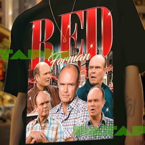 May include: Black t-shirt featuring the text "RED Forman" in a bold, red, retro font. The shirt displays a collage of images of a bald man. The background is a city street.