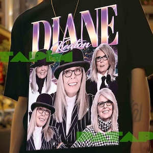 Puede incluir: Camiseta negra con un gráfico de Diane Keaton, el nombre "Diane Keaton" en una fuente degradada. El gráfico incluye múltiples imágenes de Diane Keaton con sombrero y gafas. La camiseta la lleva una persona.