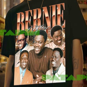 May include: Black t-shirt with a retro-style graphic that reads "BERNIE" and features images of several men. The t-shirt is worn by a person with a gold chain necklace.
