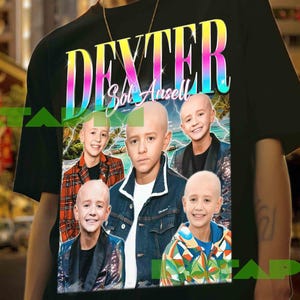 Könnte beinhalten: Schwarzes T-Shirt mit dem Namen "DEXTER" in einer Regenbogen-Schriftart und "Sol Ansell" darunter. Das T-Shirt zeigt eine Collage von fünf Bildern einer jungen Person. Das Model trägt das T-Shirt.