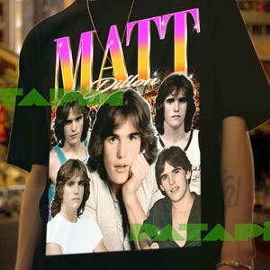 Puede incluir: Camiseta negra con un gráfico de Matt Dillon y el nombre "MATT" en rosa y amarillo. El gráfico incluye varias imágenes del actor. La camiseta la lleva una persona.