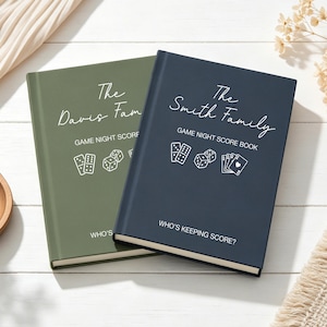 Peut inclure: Deux carnets de score pour soirées jeux à couverture rigide, l'un vert olive et l'autre bleu marine. Chaque livre présente du texte blanc indiquant The Davis Family ou The Smith Family, GAME NIGHT SCORE BOOK et WHO'S KEEPING SCORE?, avec des illustrations blanches de dominos, de dés et de cartes.