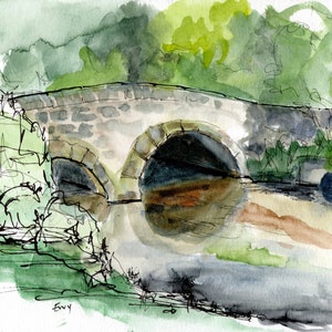 May include: A watercolor painting of a stone bridge over a river. The bridge has two arches and is surrounded by green trees. The water is a light brown color. The painting is signed "Envy" in the bottom left corner.