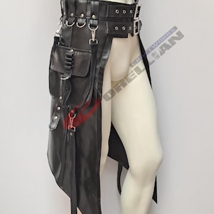May include: Black leather kilt with multiple pockets, straps, and metal hardware. The kilt features a belt with buckles and D-rings, and a long, asymmetrical front panel. The kilt is designed with a gothic or steampunk aesthetic.