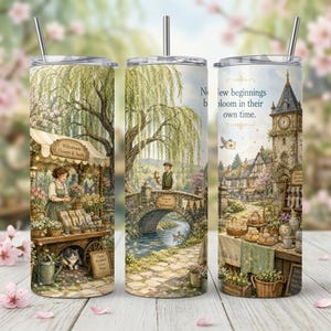 Puede incluir: Un vaso cilíndrico de acero inoxidable con pajita que presenta una ilustración detallada de una escena de pueblo con un puesto de flores, un puente de piedra, una torre de reloj y el texto New beginnings bloom in their own time.