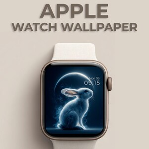 Può includere: Un Apple Watch con cinturino beige chiaro mostra uno sfondo digitale con un coniglio blu brillante su uno sfondo blu scuro. Il quadrante mostra anche l'ora e il giorno. Il testo "APPLE WATCH WALLPAPER" è in alto.