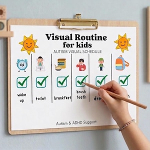 May include: A visual routine chart for kids with autism. The chart includes illustrations for wake up, toilet, breakfast, brushing teeth, and dressing. A hand is holding a pencil, marking the tasks. The chart is on a wooden clipboard.