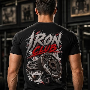 Könnte beinhalten: Ein schwarzes T-Shirt mit einem Grafikdruck auf der Rückseite, der den Schriftzug "IRON CLUB" in stilisierter weißer und roter Schrift zeigt. Das Motiv enthält zwei 20 kg Hantelscheiben, eine kleine Schale mit weißem Pulver und eine Zughilfe.