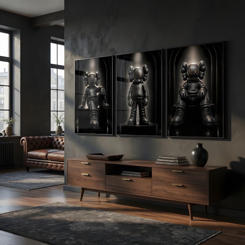 May include: A triptych of three framed wall art prints featuring black cartoon-style figures with X-shaped eyes. Each figure is depicted in a different pose within a dark, arched setting, illuminated by a soft spotlight from above.