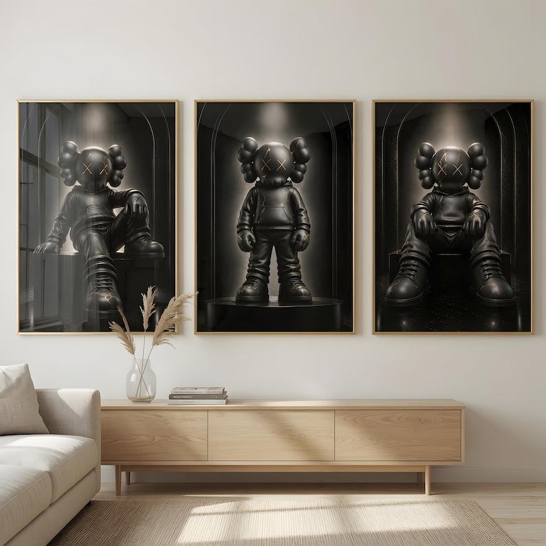 May include: A set of three framed wall art prints featuring a black cartoon-style character with X-shaped eyes. The character is depicted in different poses, including sitting and standing, within a dark, arched architectural setting.
