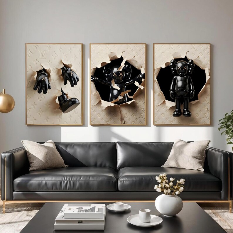 Puede incluir: Tres obras de arte enmarcadas con esculturas negras que emergen de fondos texturizados rasgados. El arte incluye un par de guantes, una bota y una figura estilo KAWS. Los marcos tienen bordes dorados.