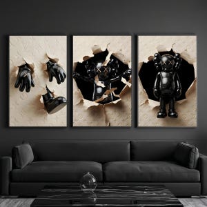 Puede incluir: Tr&iacute;ptico art&iacute;stico con figuras y accesorios negros de KAWS emergiendo de paneles beige texturizados y rasgados. Los paneles est&aacute;n grabados con un patr&oacute;n repetitivo. La obra de arte se exhibe sobre un sof&aacute; y una mesa de centro negros.