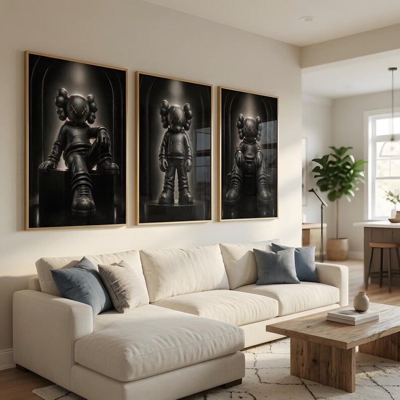 May include: A set of three framed wall art prints featuring a black KAWS-style character figure in different poses. Each print displays the character with X-shaped eyes, wearing a hoodie and sneakers, set against a dark, arched background.