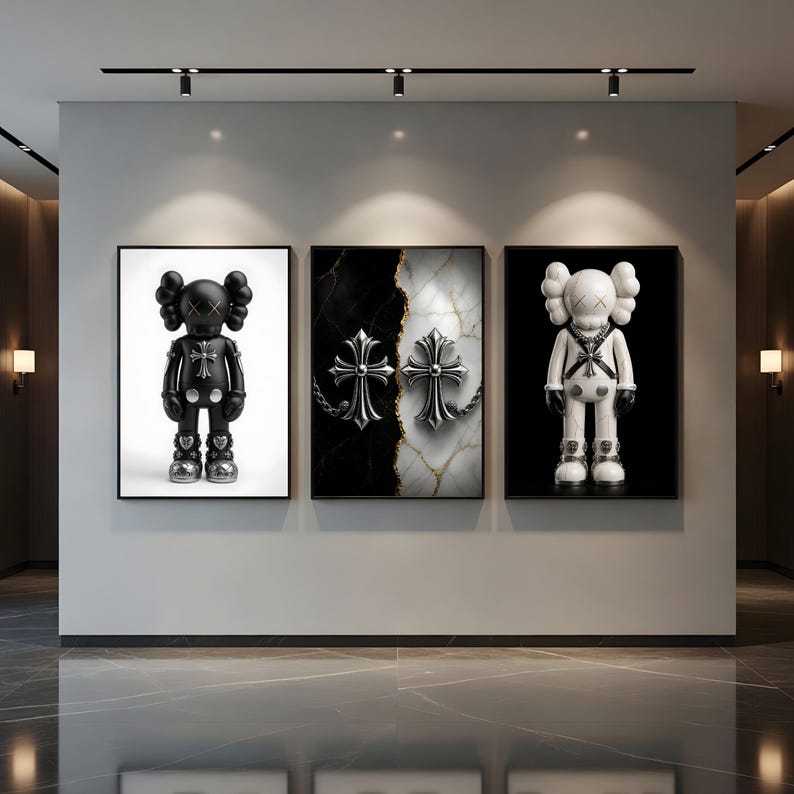 May include: Three framed art pieces. The left and right frames feature cartoon-like figures with X-shaped eyes. The center frame displays two silver crosses on a black and white marble background. All frames have black borders.