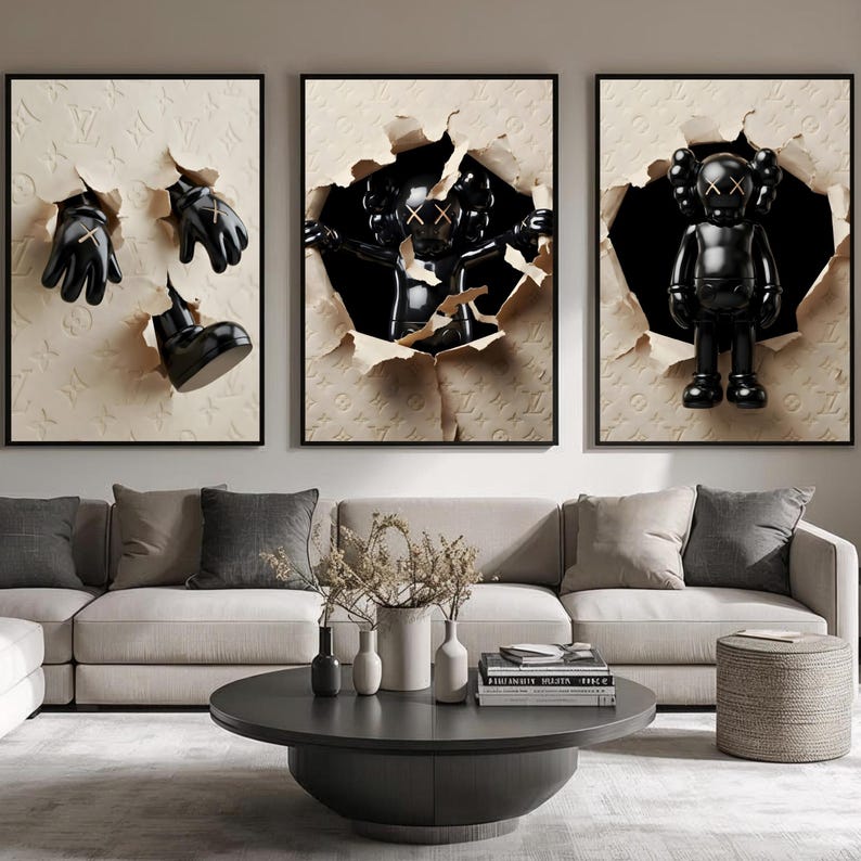 Puede incluir: Tres obras de arte enmarcadas con figuras y objetos negros que emergen de papel rasgado. El arte incluye una figura negra con ojos tachados, guantes negros y una bota negra. El fondo es un patr&oacute;n en relieve beige.