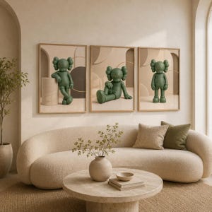 May include: A set of three framed wall art prints featuring a green cartoon character with X-shaped eyes. The character is depicted in three different poses: leaning against a cylinder, sitting on the floor, and standing upright in a neutral space.