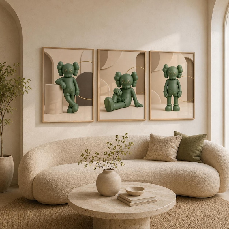 May include: A set of three framed wall art prints featuring a green cartoon character with X-shaped eyes. The character is depicted in three different poses: leaning against a cylinder, sitting on the floor, and standing upright in a neutral space.
