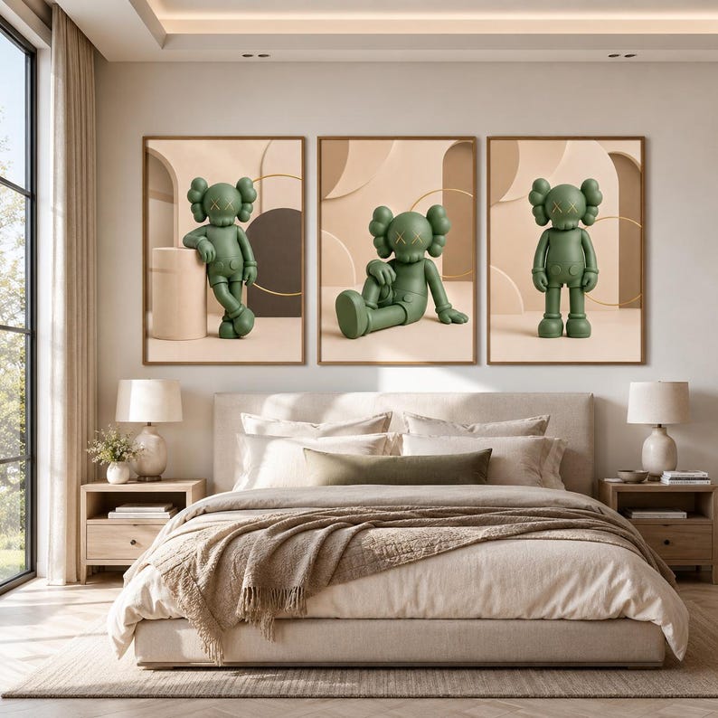 May include: A set of three framed wall art prints featuring a green cartoon character with X-shaped eyes in different poses. The character is depicted standing, sitting, and leaning against a cylindrical object, set against a neutral beige background.