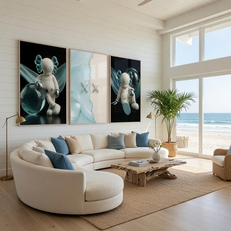 May include: A curved white sofa with blue throw pillows sits before a wooden coffee table. Three large wall art prints hang above the sofa, featuring stylized white figures with X-shaped eyes and blue translucent spheres against dark backgrounds.
