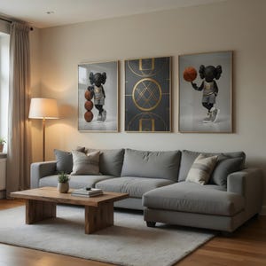 May include: Living room decor featuring three framed art pieces. Two pieces depict a black figure with basketballs and a basketball court design. A gray sectional sofa, wooden coffee table, and a floor lamp complete the room.