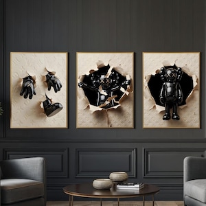 Puede incluir: Tres obras de arte enmarcadas con esculturas negras que emergen de fondos texturizados rasgados. El marco izquierdo muestra guantes y una bota. El marco central muestra una figura. El marco derecho presenta una figura de pie con los ojos tachados. Los marcos tienen bordes dorados.