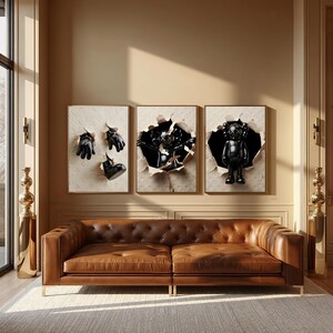 Puede incluir: Tres obras de arte enmarcadas con esculturas negras que emergen de papel rasgado. Las obras est&aacute;n sobre un sof&aacute; de cuero marr&oacute;n con un dise&ntilde;o capiton&eacute;. La habitaci&oacute;n tiene una paleta de colores neutros con acentos dorados.