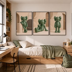 May include: A set of three framed wall art prints featuring a green cartoon character with X-shaped eyes. Each print displays the character in a different pose against a beige background with geometric shapes, including a cylinder and circles.