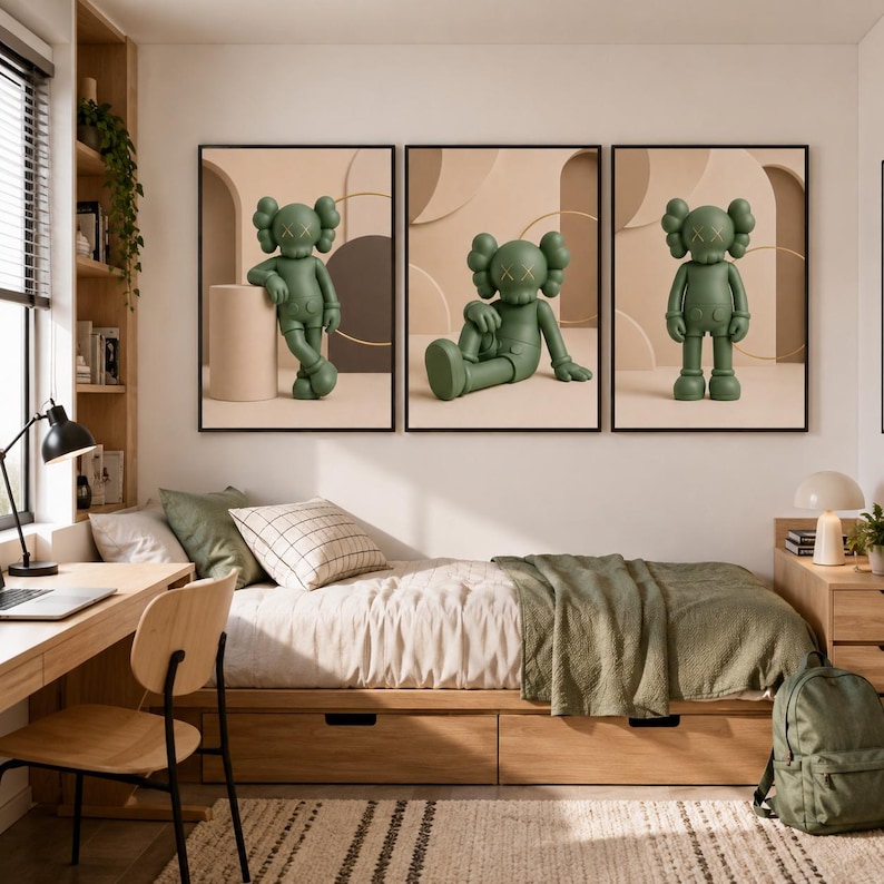 May include: A set of three framed wall art prints featuring a green cartoon character with X-shaped eyes. Each print displays the character in a different pose against a beige background with geometric shapes, including a cylinder and circles.