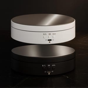 May include: Two rotating display platforms, one white and one black, with silver tops. Each platform has control buttons labeled R/L, SR, and ASA, along with IN and SV ports. The platforms are designed for product photography or display.