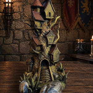 Könnte beinhalten: Eine detaillierte Baumhaus-Skulptur mit mehreren Miniaturhäusern und einer Wendeltreppe. Die Skulptur hat ein braunes und goldenes Farbschema, mit rotbedachten Häusern, die sich zwischen den Ästen befinden. Die Basis umfasst Felsen und Grün.