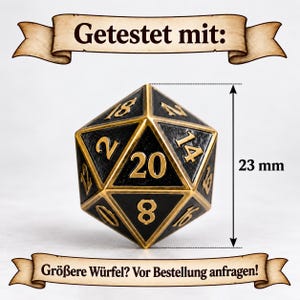 May include: A twenty-sided die with a black textured surface and gold-colored edges and numbers. The die features the text 'Getestet mit:' at the top and 'Gr&ouml;&szlig;ere W&uuml;rfel? Vor Bestellung anfragen!' at the bottom. A vertical arrow indicates a height of 23 mm.
