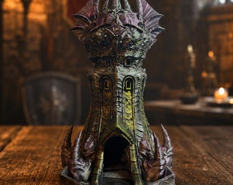 May include: A multi-colored dice tower featuring a dark, textured exterior with green and purple hues. The structure has a central arched entrance, multiple small windows, and a top section adorned with wing-like protrusions and eye motifs.