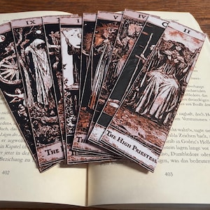 Könnte beinhalten: Ein Set aus rechteckigen Lesezeichen aus Papier mit schwarz-weißen Tarotkarten-Illustrationen, römischen Ziffern und Titeln wie The High Priestess. Die Designs zeigen detaillierte Figuren und Symbole in einer kontrastreichen Optik.