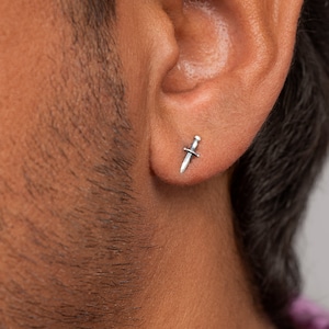 Op de afbeelding: Een zilveren oorbel in de vorm van een dolk voor één oor.