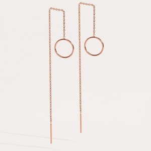 Könnte beinhalten: Ein Paar Ohrringe aus roségold mit einem Kreisdesign. Die Ohrringe haben eine lange Kette, die vom Kreis herabhängt.