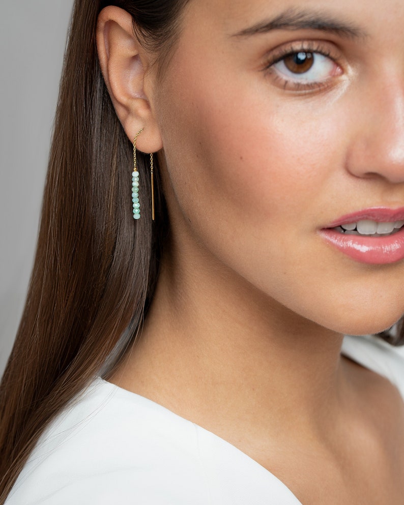 Dainty Chain Earring is a true epitome of elegance and style. This eye-catching accessory features a delicate bar gemstone meticulously threaded through a unique statement jewelry design.