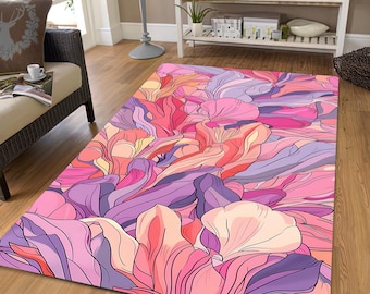 Op de afbeelding: Een rechthoekig vloerkleed met een bloemenontwerp in roze, paarse en perzikkleurige tinten. Het vloerkleed heeft een abstract patroon van overlappende bloemblaadjes en bladeren, wat een levendige vloerbedekking creëert.
