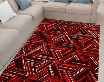 May include: A rectangular rug featuring a geometric design of red and white lines on a dark red backdrop. The rug is positioned on a light wooden floor, adjacent to a beige sectional sofa with blue and white cushions.