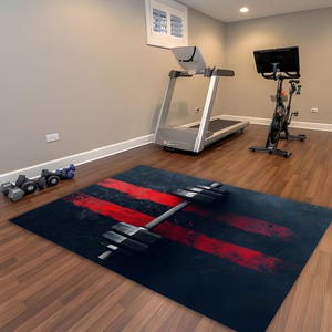 May include: A black and red fitness mat with a barbell design. The mat features three red brushstroke stripes and a silver barbell in the centre. The mat is in a home gym setting with exercise equipment.