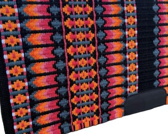 May include: A black saddle pad with a vibrant, geometric pattern in shades of orange, pink, gray, and white. The pad features a black leather reinforcement at the bottom. This item is designed for equestrian use.