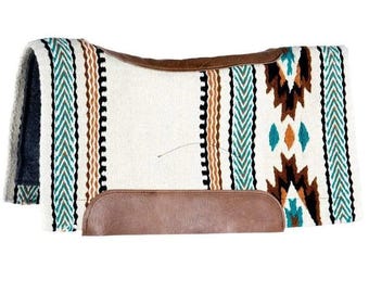 May include: A rectangular horse saddle pad featuring a cream-colored base with vertical stripes in teal, brown, and black. The pad includes brown leather-like wear patches along the top center and bottom edge, with geometric patterns.
