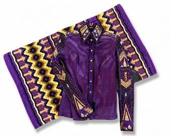 May include: A purple equestrian show shirt with intricate gold and silver embellishments on the sleeves and collar. The shirt is paired with a matching saddle pad featuring a geometric pattern in purple, gold, and black.