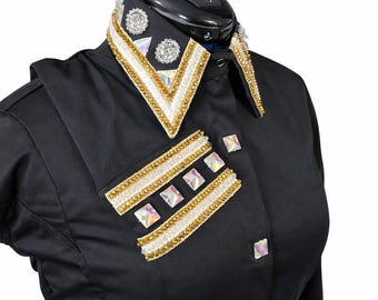 May include: A black long-sleeved shirt featuring a pointed collar and a chest panel embellished with rows of gold beads, white crystals, and iridescent square stones. The collar is decorated with matching gold beads and clear round crystals.