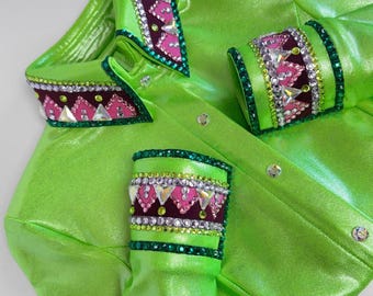 May include: A bright green, shiny shirt with decorative embellishments. The collar and cuffs feature a burgundy, pink, and crystal design. The shirt has a button-up front and is made of a reflective material.