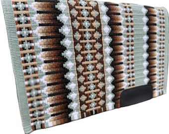 May include: A rectangular saddle pad with a woven design in shades of sage green, brown, tan, black, and white. The pad features a geometric pattern and a black leather reinforcement at the bottom.